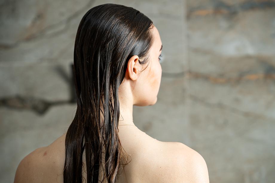 Žena se zdravými mokrými vlasy po sprše – kolekce péče o vlasy Zenea