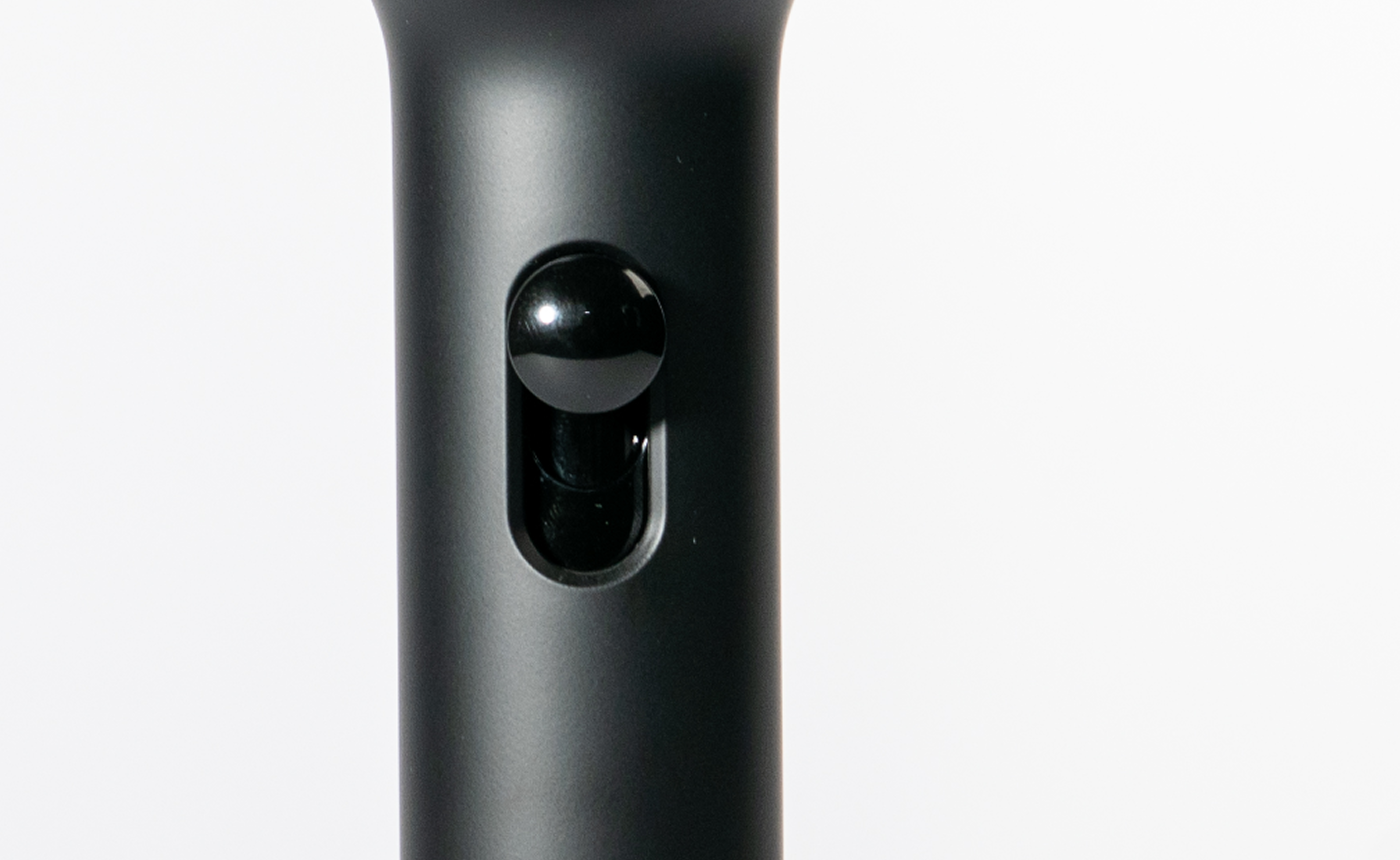 Detail tlačidla na prepínanie spray mode na čiernej filtračnej sprchovej hlavici Zenea