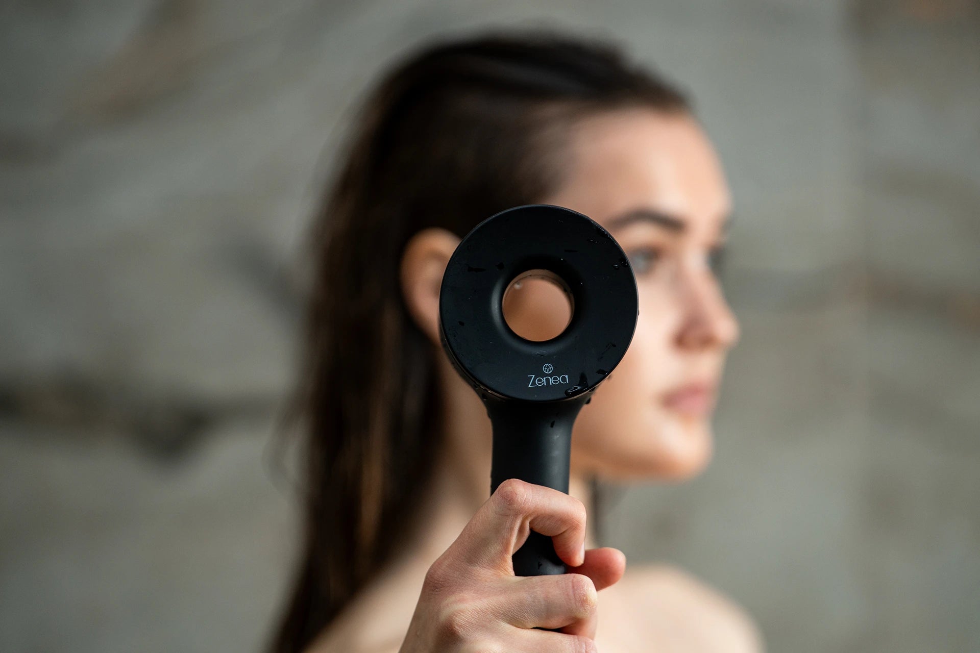 Černá filtrační sprchová hlavice Zenea v ruce detailní pohled na design a logo